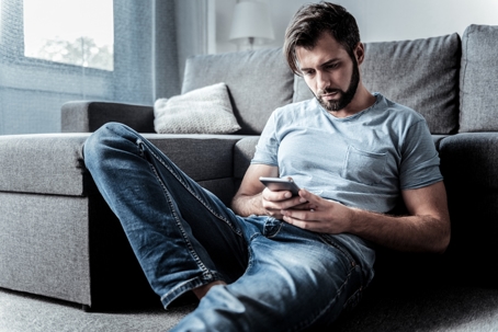 Sad cheerless man waiting for a message